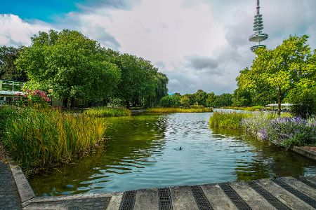 Blick von einem Wasserlauf im Park Planten un Blomen auf den Hamburger Fernsehturm