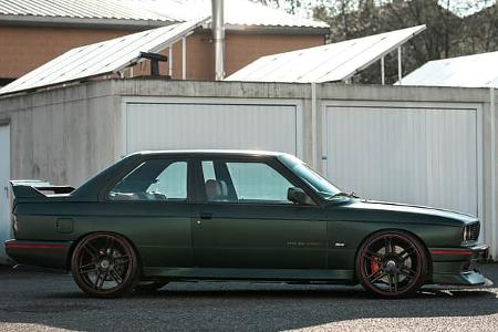 BMW E30 M3 von der Seite vor Garagen