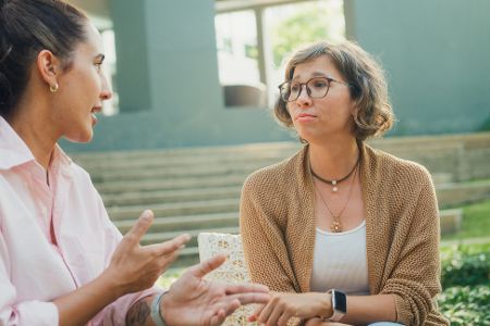 Frauen sitzen draußen bei Unterhaltung