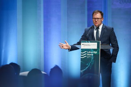 Bundesumweltminister Carsten Schneider hinter Rednerpult