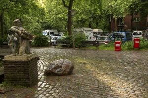 Zugepflasterte öffentliche Fläche vor einer Statue in Hamburg
