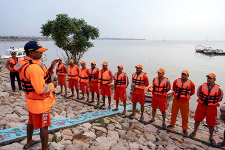 Ein Teamleiter informiert Mitglieder des indischen Katastrophenschutzes über Rettungsmaßnahmen in überschwemmten Gebieten. 