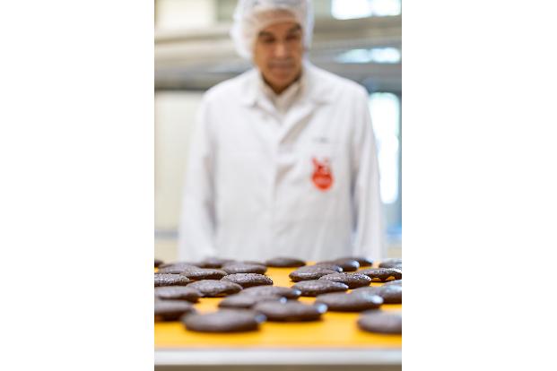 Frisch gebackene Lebkuchen laufen auf einem Band in der Produktion des Lebkuchenherstellers Schmidt. 