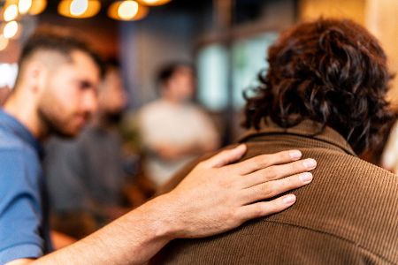 Mann klopft einem anderen Mann aufmunternd auf die Schulter