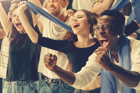 Menschen auf einer Tribüne jubeln beim Sportereignis