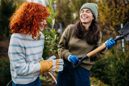 Zwei Frauen lachen bei der Gartenarbeit
