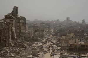 Menschen gehen auf zerstörter Straße im Gazastreifen. (Archivbild)