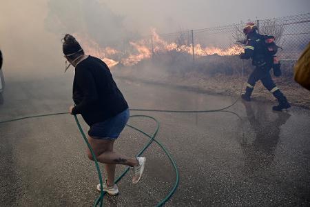 Bewohner und Feuerwehrleute bekämpfen die Flammen.