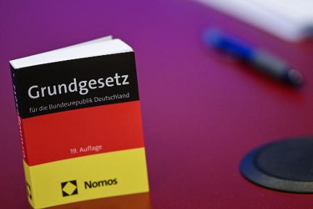 Das Grundgesetz in Miniatur-Ausgabe steht bei der Pressekonferenz zur AfD auf einem Tisch. 