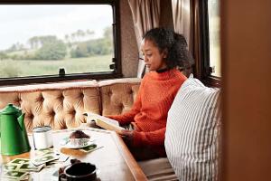 Frau lesend beim Camping