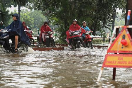 In Hanoi bahnten sich viele Motorradfahrer ihren Weg durch die Wassermassen.