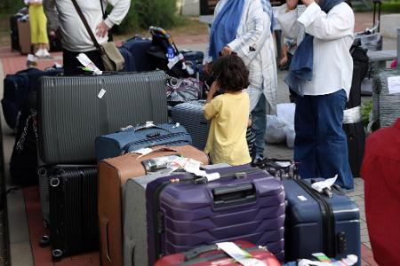 Menschen aus Afghanistan, die zuvor mit einem Flugzeug am Flughafen Hannover gelandet sind, stehen im Grenzdurchgangslager Friedland an ihren Koffern. 