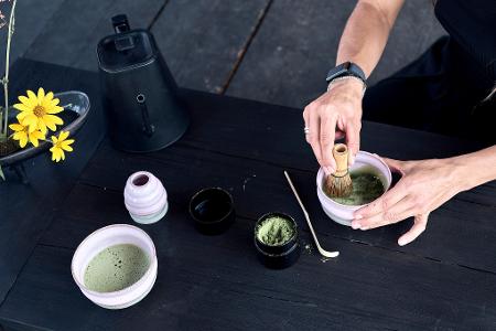 Das Matcha-Pulver wird mit Wasser und einem Besen schaumig geschlagen. 