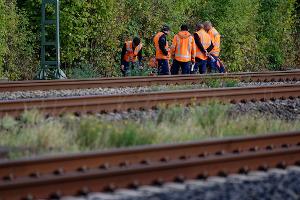 Bahn-Mitarbeiter stehen am Rand der Strecke Köln-Düsseldorf. 