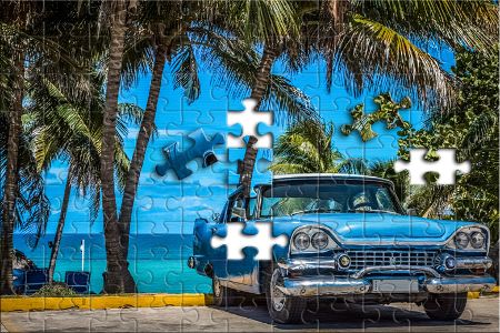 Amerikanischer blauer Oldtimer parkt unter Palmen in Varadero Kuba
