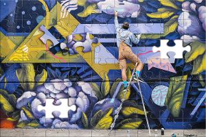 Streert Künstler auf einer Leiter Malen von Graffiti mit Sprühfarbe