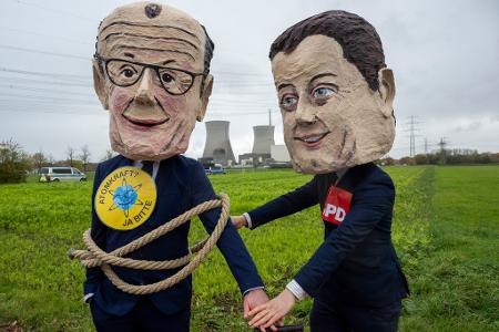 Als Bundeskanzler Friedrich Merz (l) und SPD-Vorsitzender Lars Klingbeil verkleidete Atomkraftbefürworter demonstrieren gegen die Sprengung.