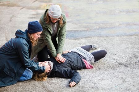 Zwei Frauen kümmern sich um ein verletztes Kind