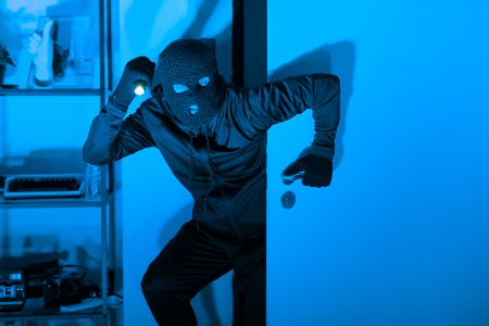 Maskierter Einbrecher schleicht sich nachts in Wohnung