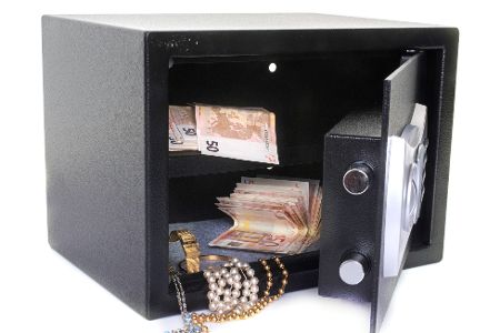 Tresor mit offen stehender Tür, aus dem Geld und Schmuck rausschaut