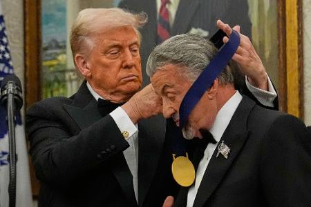 US-Präsident Donald Trump hängt der Actionfilm-Ikone Sylvester Stallone eine Medaille um. 
