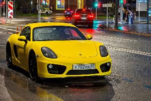 Porsche 718 Cayman in Moskau bei Nacht und Regen