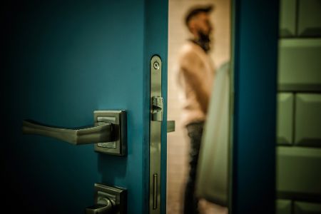 Junger Mann steht in einer öffentlichen Toilette an einem Urinal