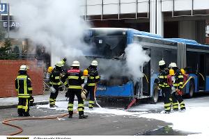 Einsatzkräfte der Feuerwehr München bei einem brennenden Linienbus.