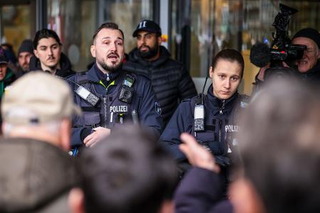 Polizeibeamte sprechen mit möglicherweise betroffenen Kunden der Sparkassenfiliale in Buer.