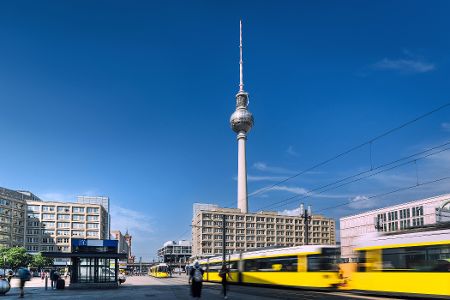 Fernsehturm in Berlin, davor eine gelbe S-Bahn
