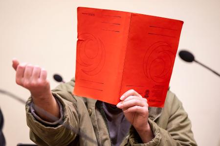 Der Angeklagte verdeckte sein Gesicht zum Prozessauftakt zunächst mit einer Mappe.