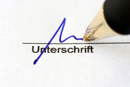 Kugelschreiber setzt eine Unterschrift auf ein Papier
