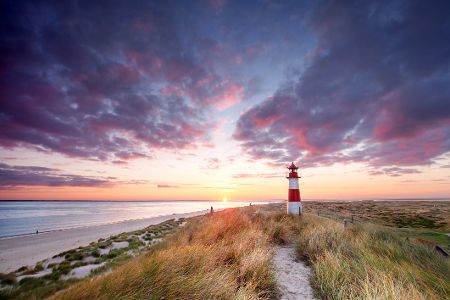 Leuchtturm auf einem Deich vor dem Sonnenuntergang