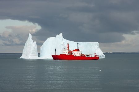 Forschungsschiff vor einem Eisberg