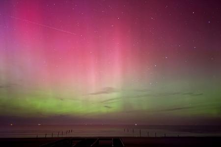 Polarlichter leuchten am Nachthimmel über der Nordsee.