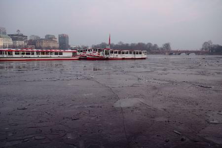 Ausflugsschiffe liegen an der teils gefrorenen Binnenalster in Hamburg. 