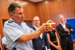 Ein Polizist erklärte die Funktionsweise eines Distanz-Elektroimpulsgeräts im vergangenen Jahr im Innnenministerium. (Archivfoto)