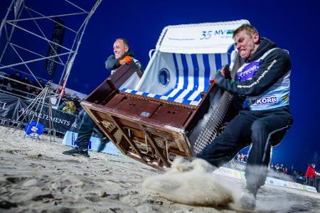 Sie geben alles: Das Team „Quad Safari Usedom“ mit Phillip Schmidt (l) und Finley Liemen (r) gewinnt den Finallauf bei der 18. Strandkorb Weltmeisterschaft auf der Insel Usedom mit einer neuen Weltrekordzeit von 4,56 Sekunden. Die Zweierteams müssen bei dem Wettkampf einen etwa 60 Kilogramm schweren Strandkorb über die 20 Meter lange Strecke über den Ostseestrand ins Ziel schleppen.