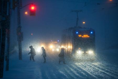 Menschen gehen bei Schneefall durch die Innenstadt von Toronto.