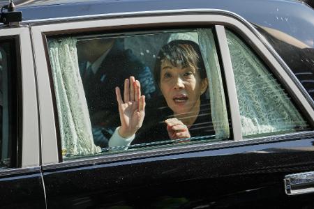 Die japanische Premierministerin Sanae Takaichi winkt von ihrem Fahrzeug aus.