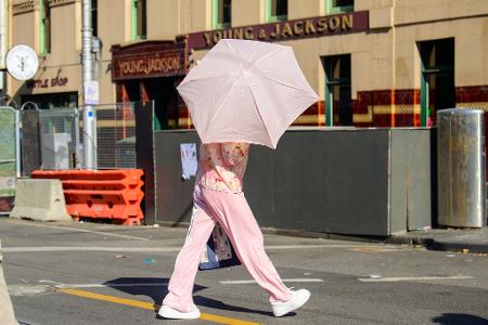 Eine Frau benutzt einen Regenschirm, um sich vor der Sonne zu schützen.