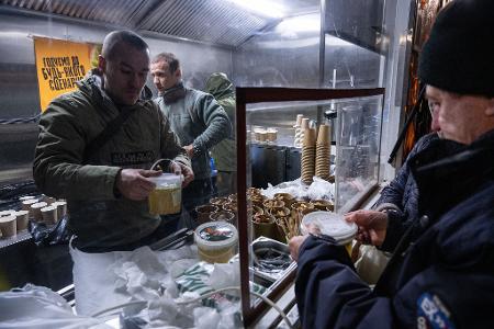 In Kiew geben die Streitkräfte warme Mahlzeiten für Menschen aus, die in ihren Häusern keinen Strom mehr haben.