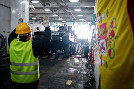 Ein Panzer wird vom Flagschiff auf ein Landeboot verladen. 