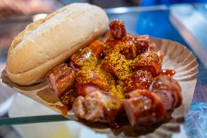 Currywurst mit Brötchen in einer Schale