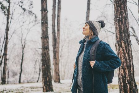 Frau im Winter geht im Wald spazieren