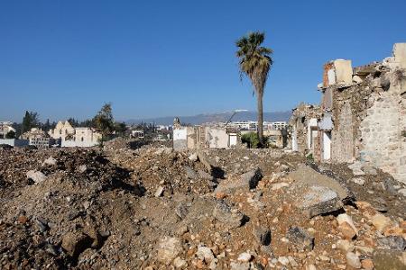 Links ist die Fassade der Kirche inmitten der Zerstörung zu sehen.