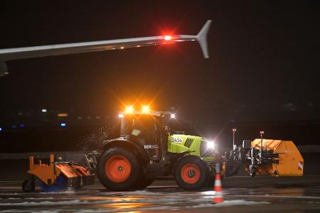 Ein Räumfahrzeug fährt über das Flugfeld des Berliner Flughafen BER.