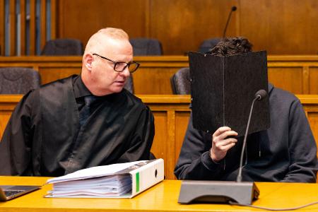 Der wegen Mordes angeklagte junge Mann sitzt neben seinem Verteidiger Michael Rehberger im Landgericht Saarbrücken.