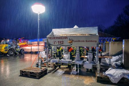 In Schlüsselfeld im Landkreis Bamberg befüllen Feuerwehrleute Sandsäcke.