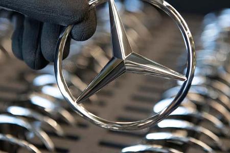 Hand hält einen Mercedes-Stern